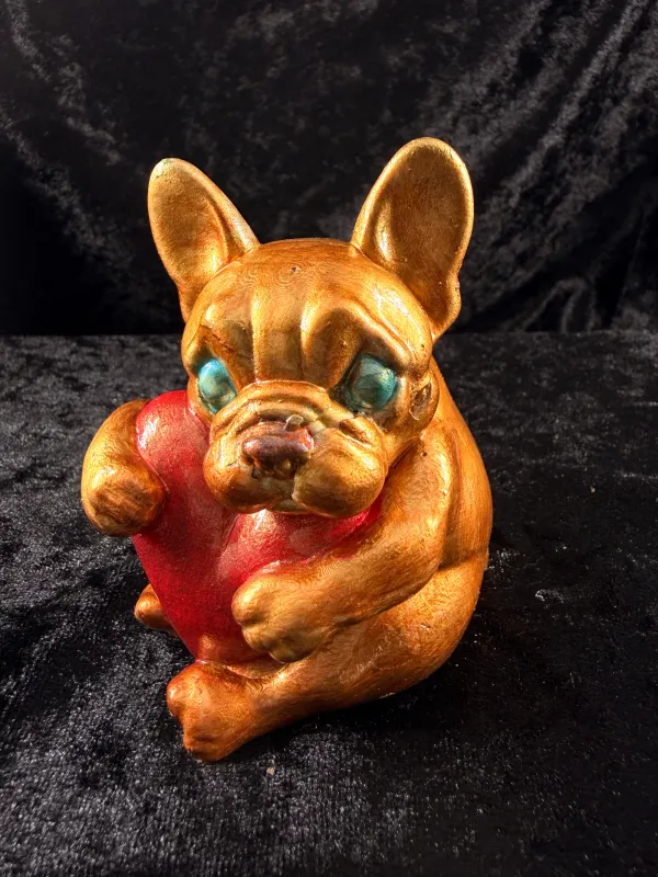 Orange bulldog holding a heart